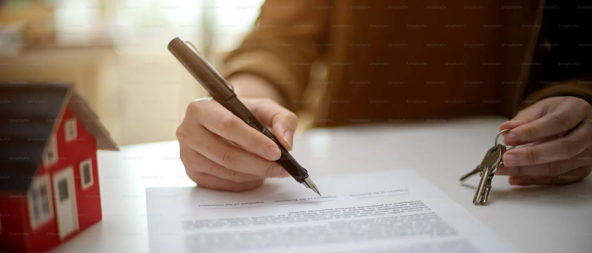 Borrower insurance contract document on a desk with glasses and a pen
