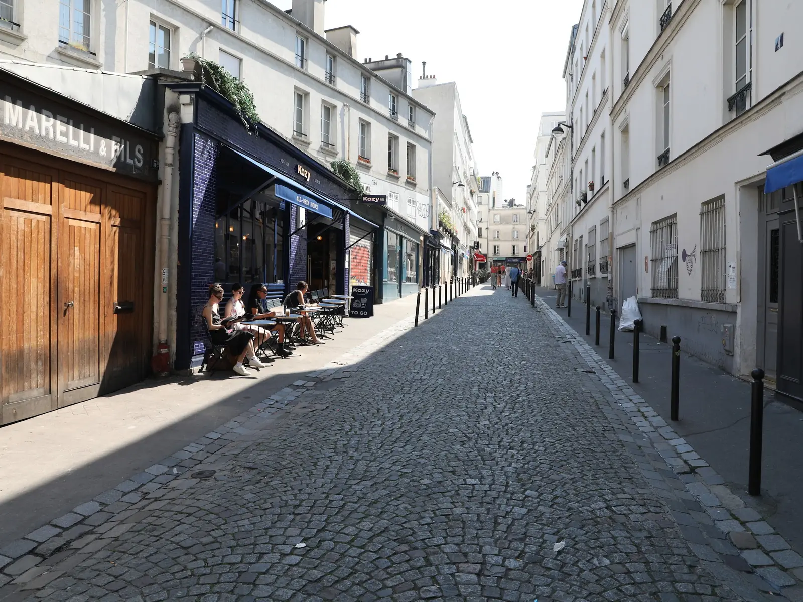 Rue pavée parisienne et devantures de commerces