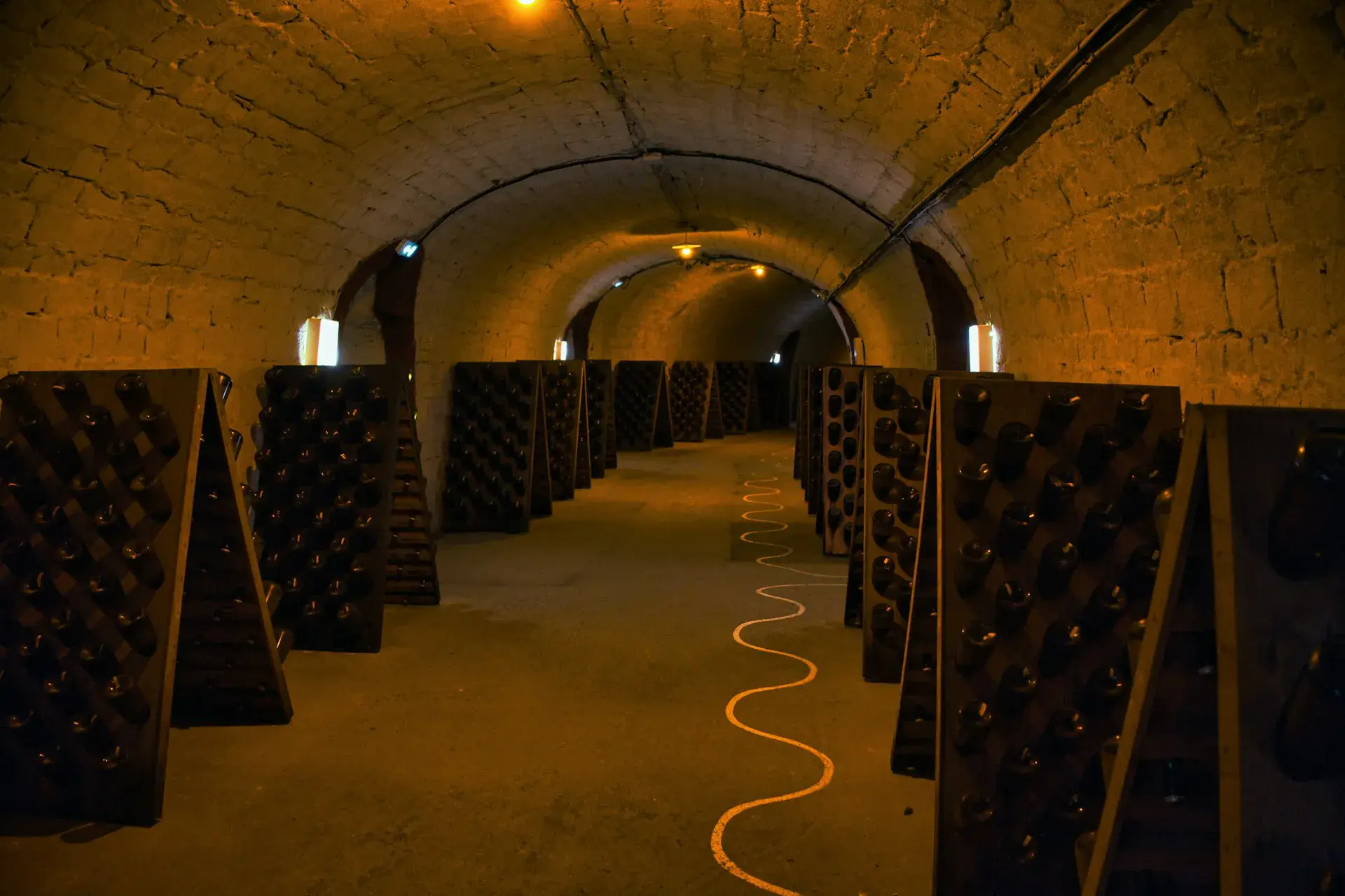 Cave voûtée en pierre dans un immeuble ancien parisien, aménagée en espace de stockage