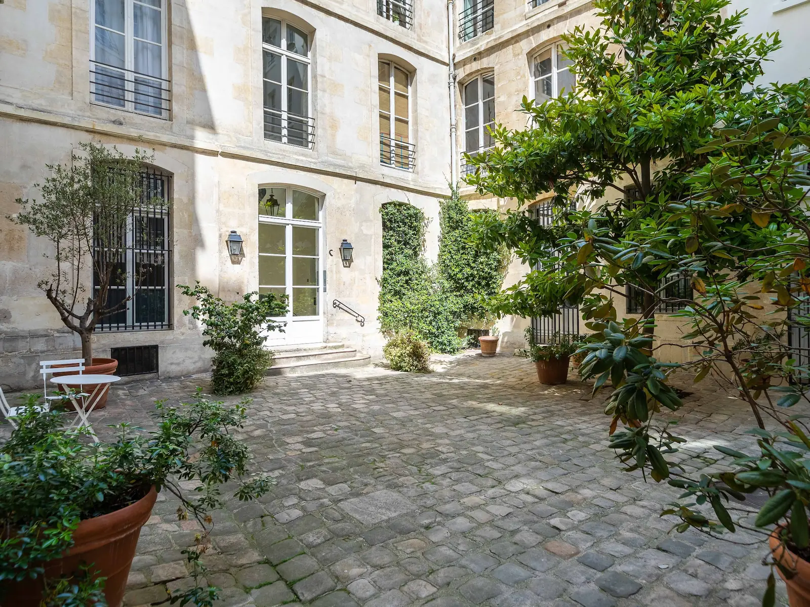 Cour pavée et végétalisée d'un immeuble parisien
