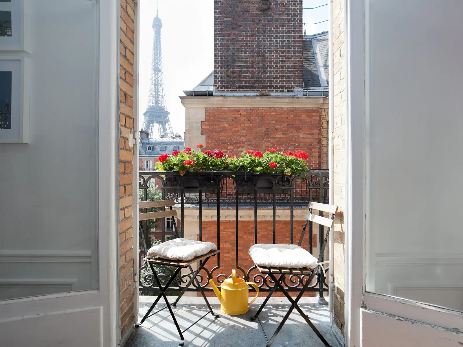 Fenêtre ouverte sur un balcon parisien avec la tour Eiffel