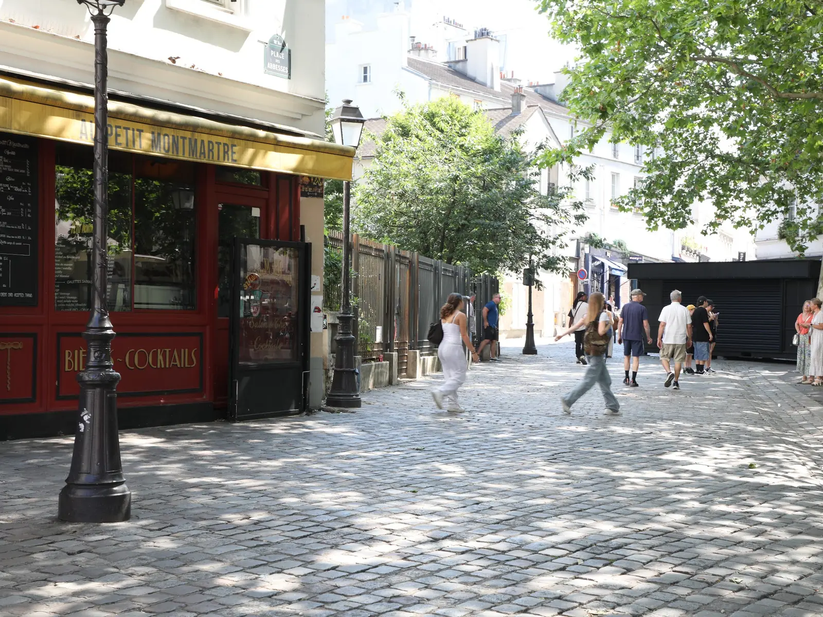Rue pavée des Batignolles devant la terrasse d'un café