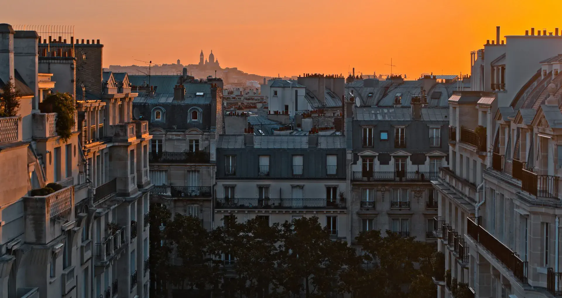 Vue sur les toits de Paris depuis un appartement avec une fenêtre ouverte