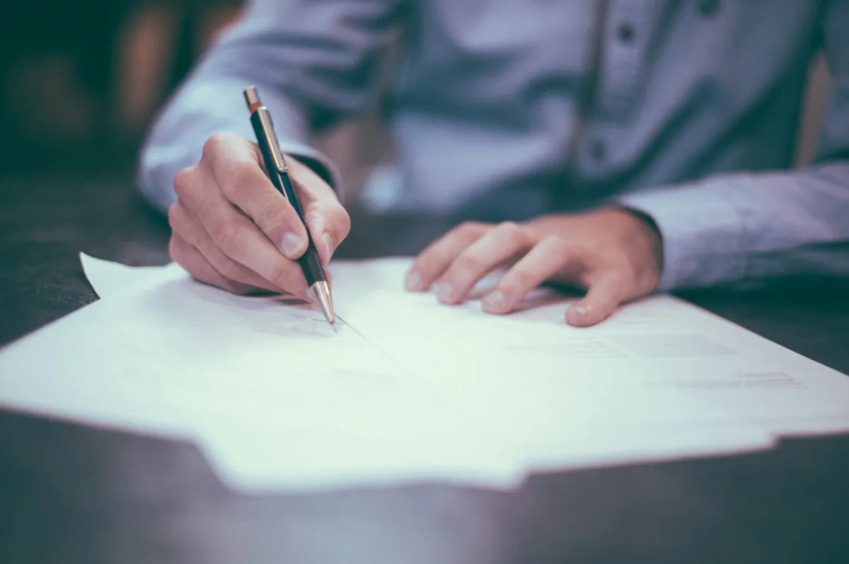 Acte notarié et documents de succession sur une table en bois