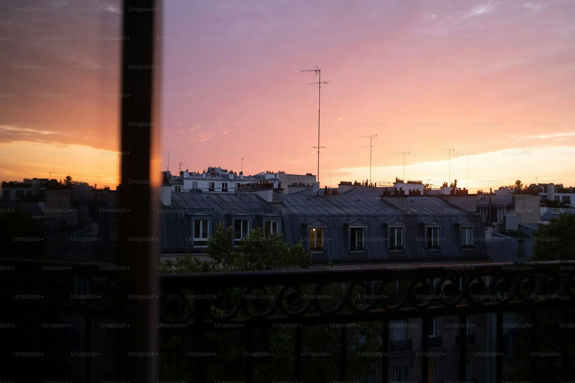 Façade d'un immeuble parisien ancien avec balcons en fer forgé sous un ciel ensoleillé