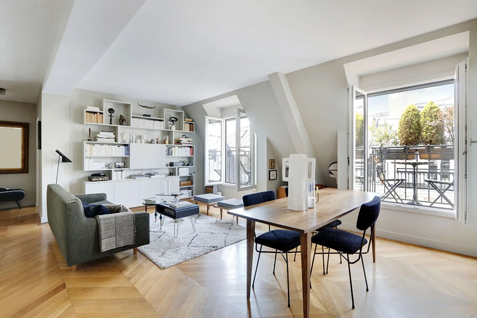 Séjour sous les combles d'un immeuble parisien, poutres apparentes et lumière zénithale