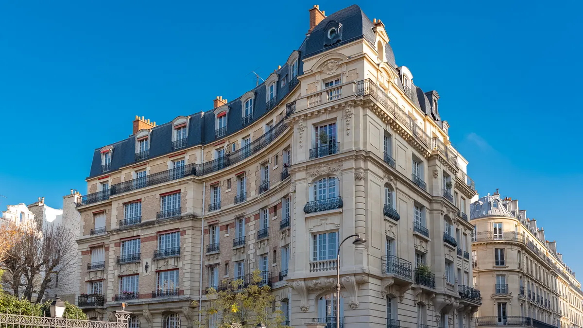 Façade haussmannienne d'angle à Paris, balcons filants et pierre de taille