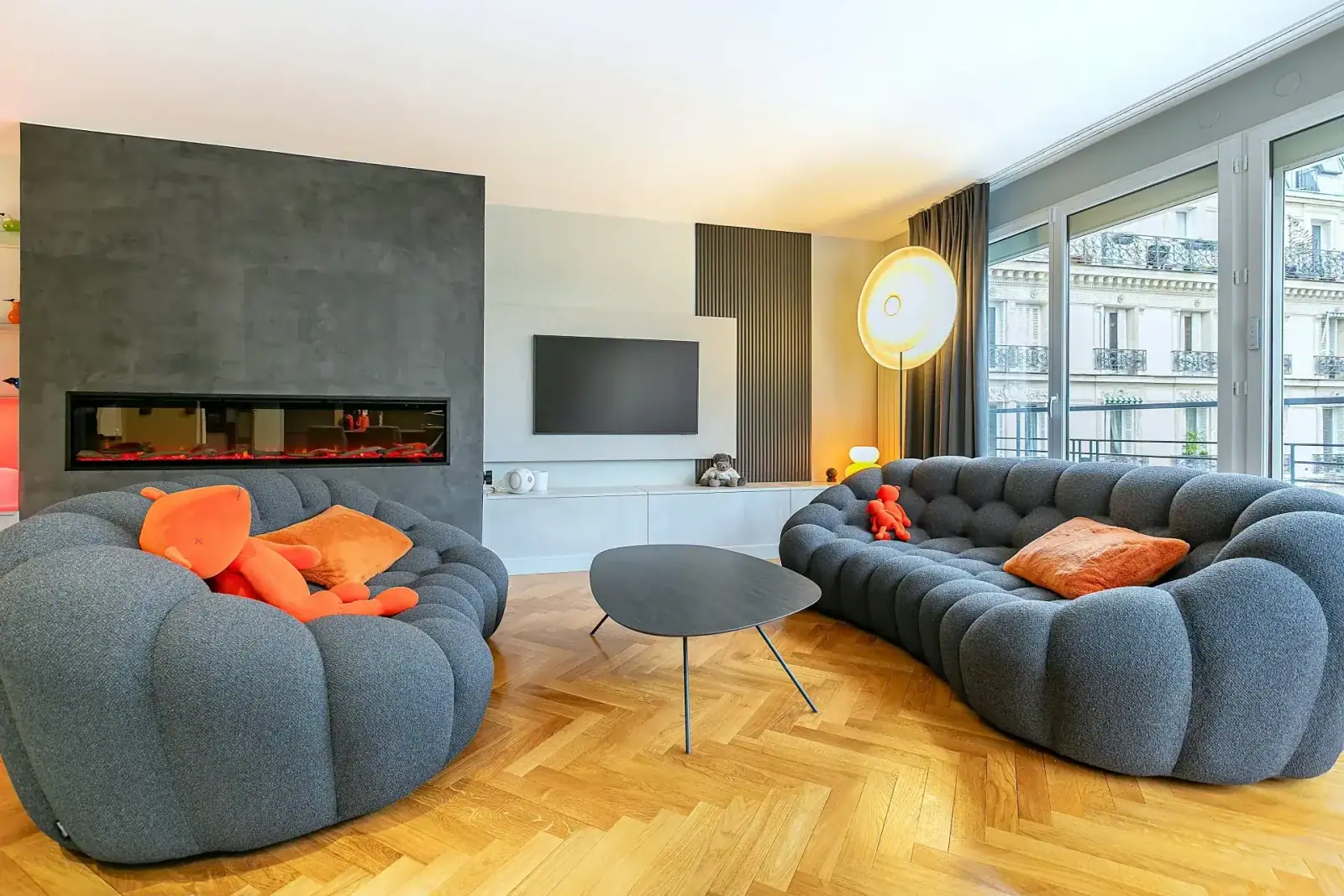 Salon d'un appartement parisien avec cheminée en marbre et parquet ancien