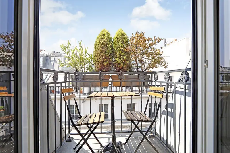 Balcon parisien avec table de bistrot en fer