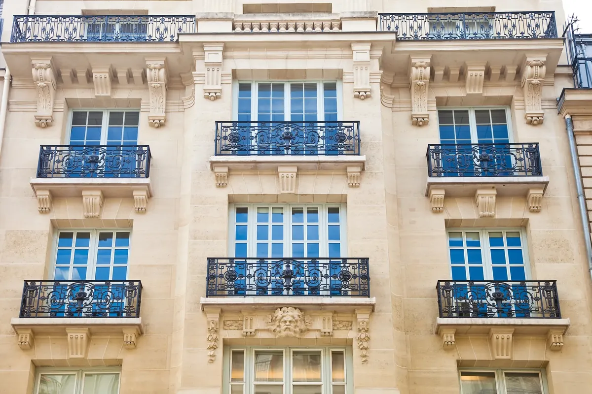 Façade parisienne en pierre de taille avec balcons en fer forgé
