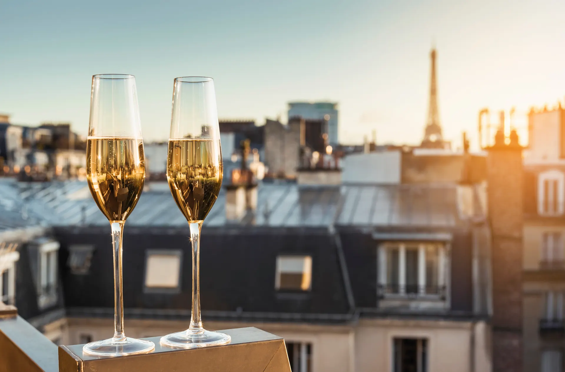 Deux coupes de champagne sur un toit parisien face à la Tour Eiffel